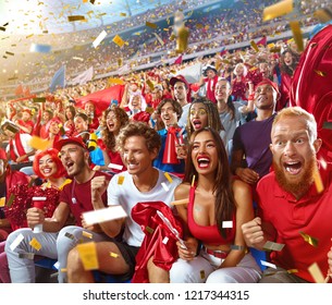 Young Sport Supporter Happy Fans Cheering At Stadium. Group Of Young Woman And Man Support The Football Team During The Match