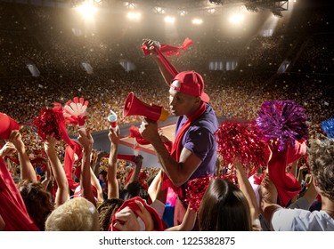 Young Sport Supporter Happy Fans At Basketball Arena. Beautiful Black Man Support The Basketball Team During The Game And Shouting Into A Red Mouthpiece