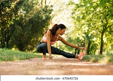 Young sport woman exercising before jogging outside in nature