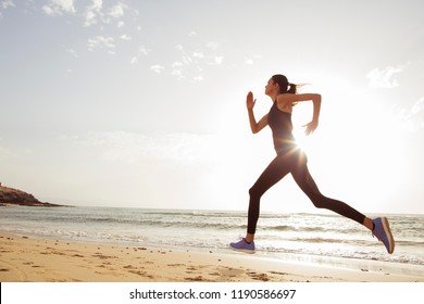 Young Sport Woman Running In The Morning On The Beach.