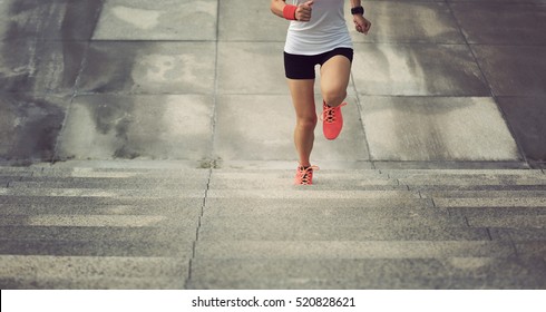 young sport woman running upstairs on city stairs - Powered by Shutterstock