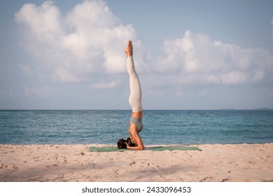 Young sport woman wearing sport suit practice yoga on the beach .Yoga is meditation and healthy sport relaxing on summer holiday with blue sea and sky background. - Powered by Shutterstock