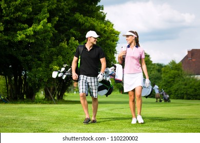 Young sportive couple playing golf on a golf course, they walking to the next hole - Powered by Shutterstock
