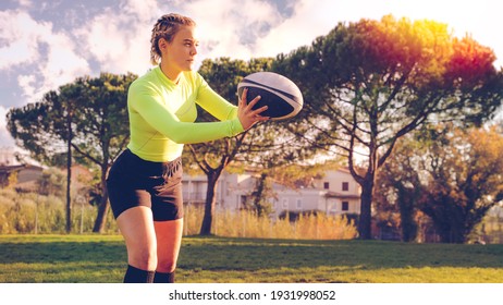 young sportive girl in uniform of rugby football player in a field. American football woman player in action holding a ball. Sport and lifestyle concept - Powered by Shutterstock