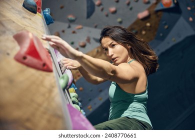 Young sportive, muscular woman, bouldering instructor training, practicing indoors, climbing wall. Concept of bouldering, sport climbing, hobby, active lifestyle, training course - Powered by Shutterstock