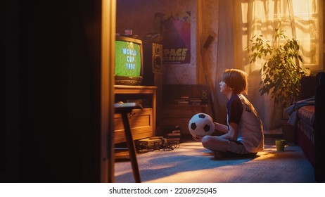 Young Sports Fan Watches A Soccer Match On Retro TV In His Vintage Room With Dated Interior. Boy Supporting His Favorite Football Team, Feeling Proud When Players Score A Goal. Nostalgic Childhood.