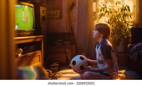 Young Sports Fan Watches A Soccer Match On TV At Home. Curious Boy Supporting His Favorite Football Team, Feeling Proud When Players Score A Goal. Nostalgic And Retro Childhood Concept.