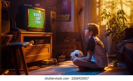 Young Sports Fan Watches A Soccer Match On Retro TV In His Room With Dated Interior. Boy Supporting His Favorite Football Team, Feeling Proud When Players Score A Goal. Nostalgic Childhood Concept.