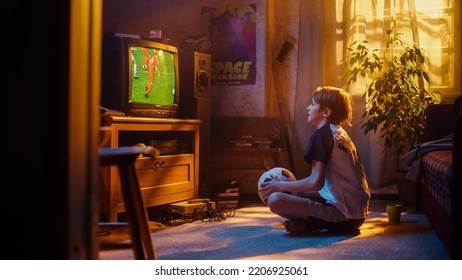 Young Sports Fan Watches A Soccer Match On Retro TV In His Room With Dated Interior. Boy Supporting His Favorite Football Team, Proud When Players Score A Goal. Nostalgic Childhood Concept.