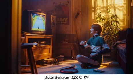 Young Sports Fan Watches A Tennis Match On Retro TV In His Room With Dated Interior. Happy Boy Supporting His Favorite Player, Feeling Excited About The Tournament. Nostalgic Childhood Concept.