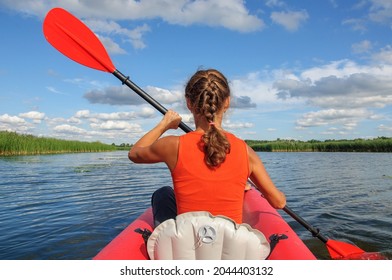 A Young Sports Girl Floats On The Zdwyzh River On A Red Kayak With A Black Dog Cocker Spaniel. Ukraine