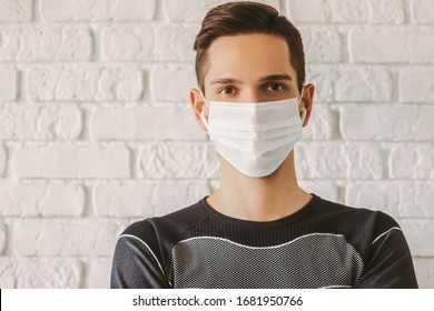 Young sports man in protective mask on face for personal protection against COVID-19. Training at home due to coronavirus quarantine. Confident man professional fitness trainer in medical face mask - Powered by Shutterstock