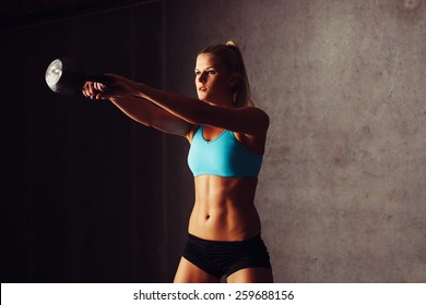 Young Sports Woman Training Kettlebell Swing