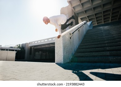 Young sportsman practicing parkour and free running outdoor by doing a wall spin. Sporty young practicing parkour in an urban space. - Powered by Shutterstock