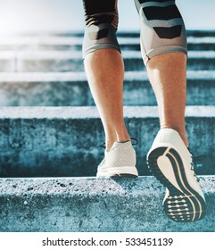  Young Sportsman Walking Upstairs In Running Shoes.Close Up Shot Of Runner's Shoes. Sport, Fitness, Workout Concept.