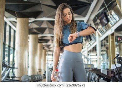 Young Sportswoman Checking Her Exercise Activity And Burned Calories On Smartwatch After Workout In Gym