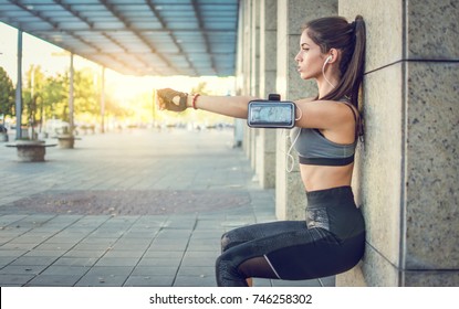 Young Sportswoman Doing Squats Against Wall Outdoors. 