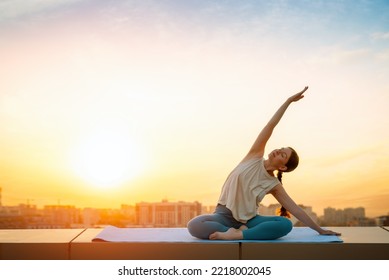 Young sportswoman is doing yoga exercise on rooftop of parking, garage in summer day morning. - Powered by Shutterstock