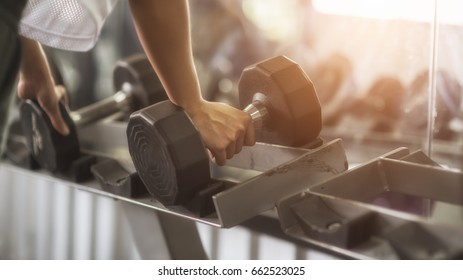 Young Sportswoman Lifting Weights In Gym.