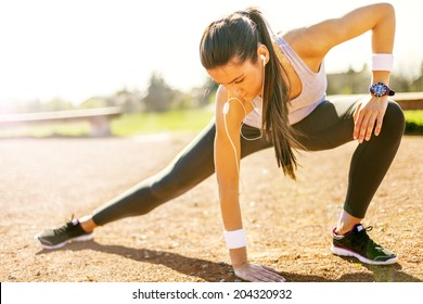 Young sportswoman stretching and preparing to run. - Powered by Shutterstock