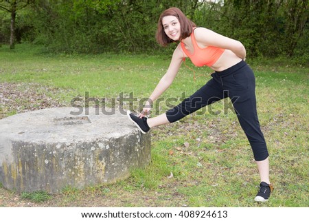 Young sportswoman stretching and preparing to run.