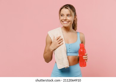 Young sporty athletic fitness trainer instructor woman wear blue tracksuit spend time in home gym hold water bottle look aside on area isolated on pastel plain pink background. Workout sport concept - Powered by Shutterstock