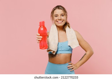 Young Sporty Athletic Fitness Trainer Instructor Woman Wear Blue Tracksuit Spend Time In Home Gym Give Water Bottle Isolated On Pastel Plain Light Pink Background. Workout Sport Motivation Concept.