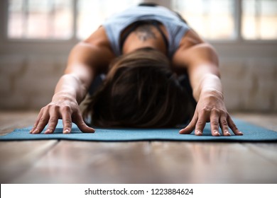 Young Sporty Attractive Woman Practicing Yoga, Doing Child Exercise, Balasana Pose, Working Out, Wearing Sportswear, Indoor Close Up, At Yoga Studio Or At Home. Well Being Concept