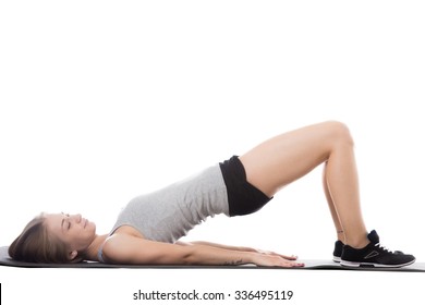 Young Sporty Beautiful Woman Doing Fitness Training On Mat, Bridge Exercise For Abs, Back And Shoulders, Full Length Isolated Studio Image On White Background