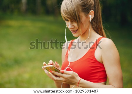 Similar – Woman with earphones listening music in smartphone