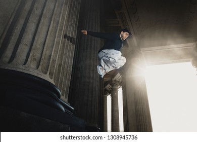 Young sporty man doing parkour in city. Athlete is practicing freerunning. Copy space - Powered by Shutterstock