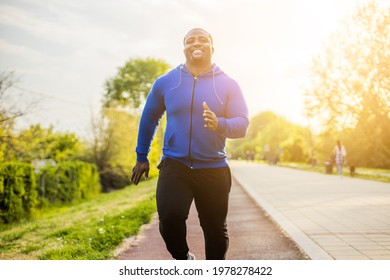 Young Sporty Man Enjoys Jogging .