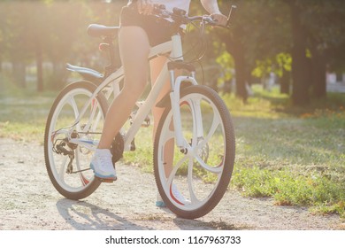 Young sporty woman with a bike on a sunset, soft focus background - Shutterstock ID 1167963733