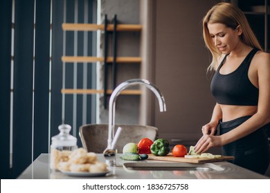 Young sporty woman cooking at the kitchen - Powered by Shutterstock