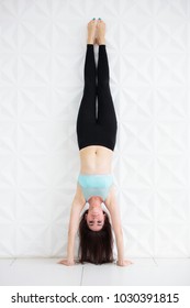 Young sporty woman doing a handstand