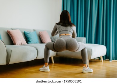 Young Sporty Woman Doing Squat Morning Exercise. Home Fitness Routine. Woman With Strong Glutes Workout At Home. Female Gymnastics. Butt Workout Motivation.