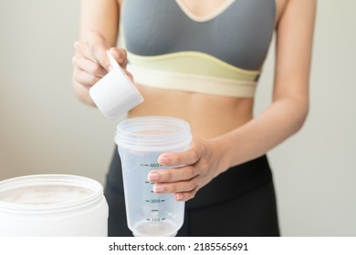 Young Sporty Woman Pouring Protein Powder Into A Cup To Make Replacement Food Meal After Workout