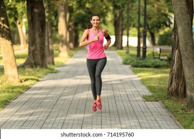 Young Sporty Woman Running In Green Park