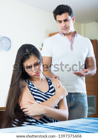 young spouses trying to put things right after bad argument indoors