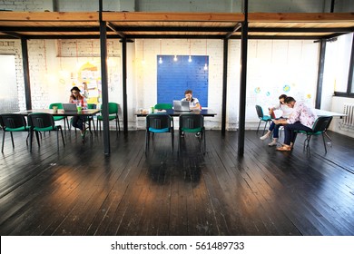 Young Startup Group Working In Modern Office. Open Space, Laptops And Paperwork.