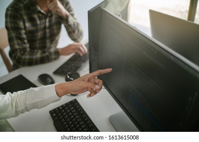 Young startup Programmers Sitting At Desks Working On Computers screen for Developing programming and coding to find solution to problem on New Application