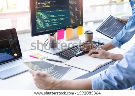 Young startup Programmers Sitting At Desks Working On Computers screen for Developing programming and coding to find solution to problem on New Application