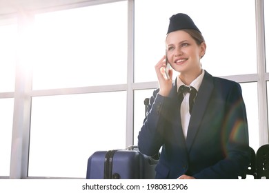 Young Stewardess Talking By Phone At The Airport