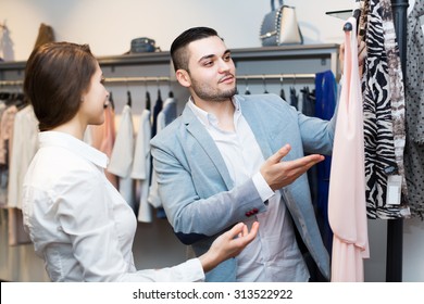 Young Store Clerk Serving Purchaser At Fashionable Apparel Store