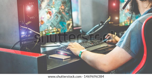 Young streamer gamer playing at e-sports competition - Male guy having fun gaming and streaming online - New technology game trends and entertainment concept - Focus on smartphone