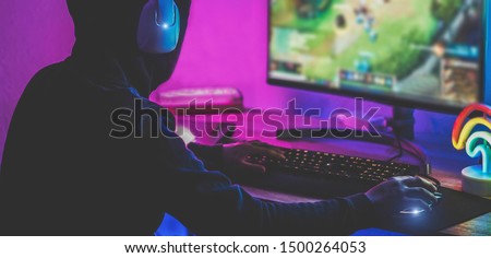 Young streamer gamer playing at strategy game in broadcast browser - Male guy having fun gaming and streaming online - New technology game trends and entertainment concept - Focus on right hand