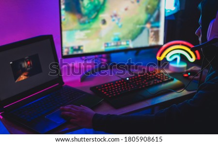 Young streamer gamer playing at strategy game in broadcast browser - Male guy having fun gaming and streaming online - New technology game trends and entertainment concept - Focus on his nose
