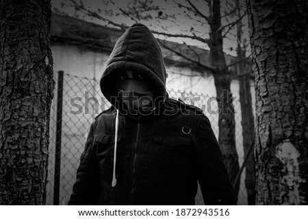 Young street gang with mask in park, social problem