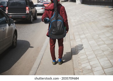 Young Street Musician Keeping Guitar Case On His Back