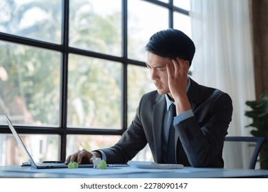 Young stressed Asian businessman working in the office. Businessman thinking too much work concept in the office. - Shutterstock ID 2278090147